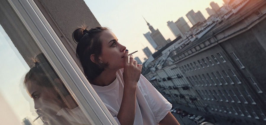 girl smoking a joint out a window in Surrey BC.