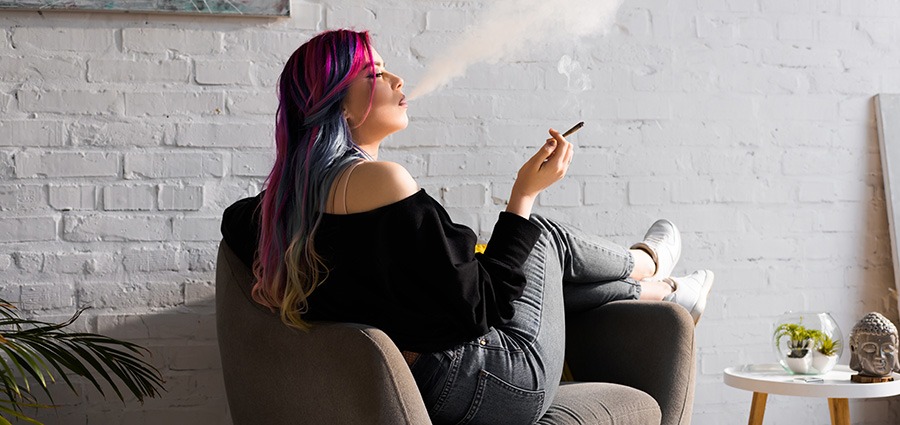Woman relaxing smoking best hybrid strains. hybrid strains. buy hybrid strains online. order weed online. best weed store near you. best pot shop in Canada. Where to buy weed.