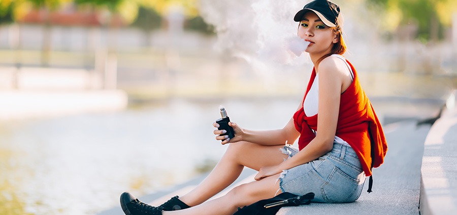Woman using a THC vape pen in Surrey BC near an online dispensary for mail order marijuana and same-day weed delivery.